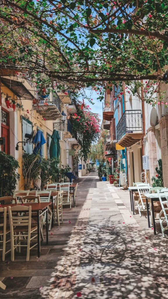 Ruela charmosa em Nafplio com casinhas coloridas, flores e atmosfera acolhedora típica da cidade